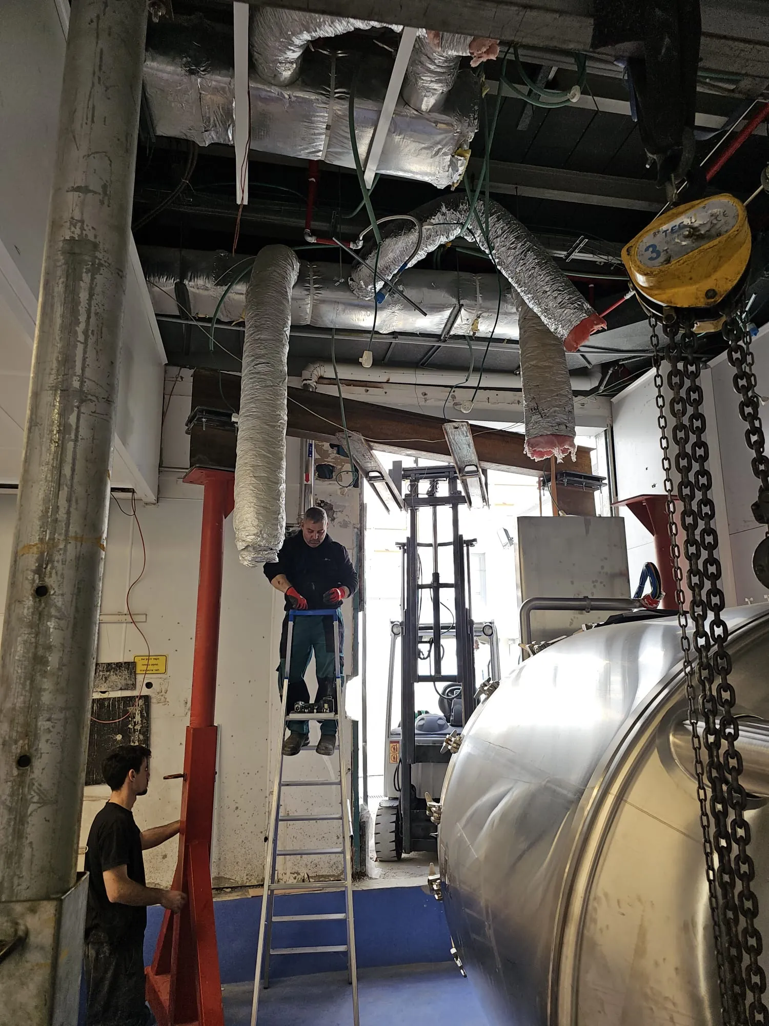 צוות מבצע ריגינג עם שרשראות בתוך חלל מפעל